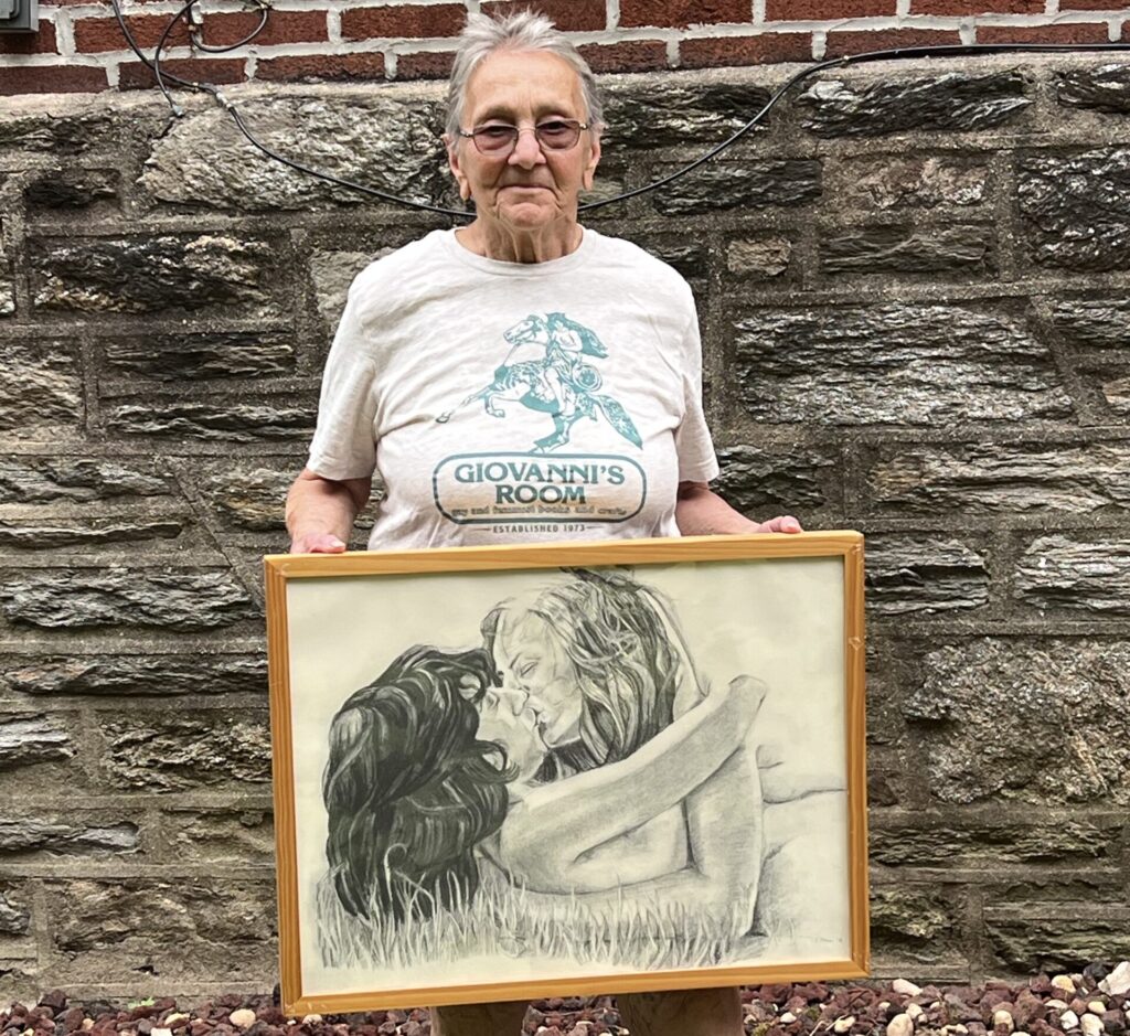 Arleen Olshan holds one of her drawings she alleges was censored by the Mt. Airy Art Garage Board. The drawing depicts two women in bed together.