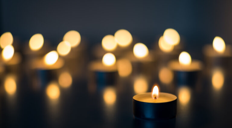 Flame of many candles burning on the background in blue and yellow color
