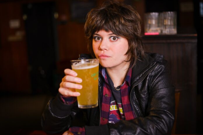 Anna Faye Lieberman drinks a beverage while sitting at a bar