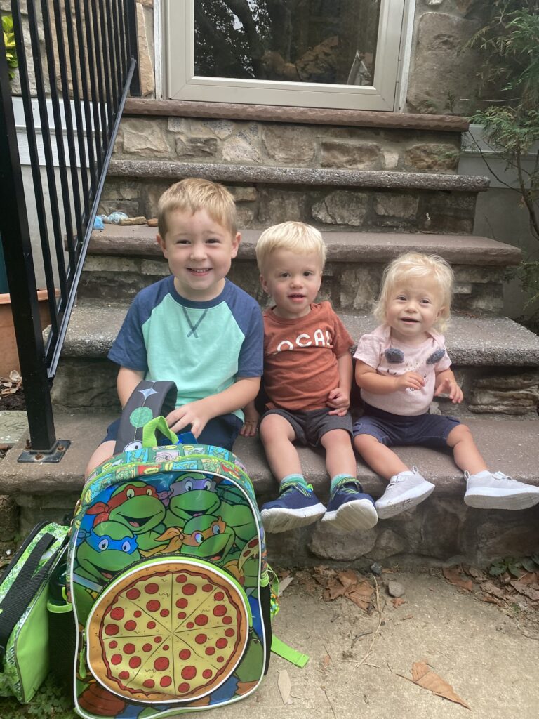 Jackson sits on a step with his siblings, August and Avery