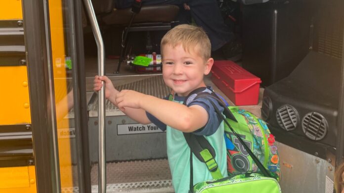 Jackson getting on the school bus for his first day of kindergarten
