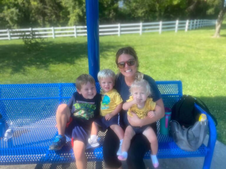 Jen sits at a picnic table with her kids.