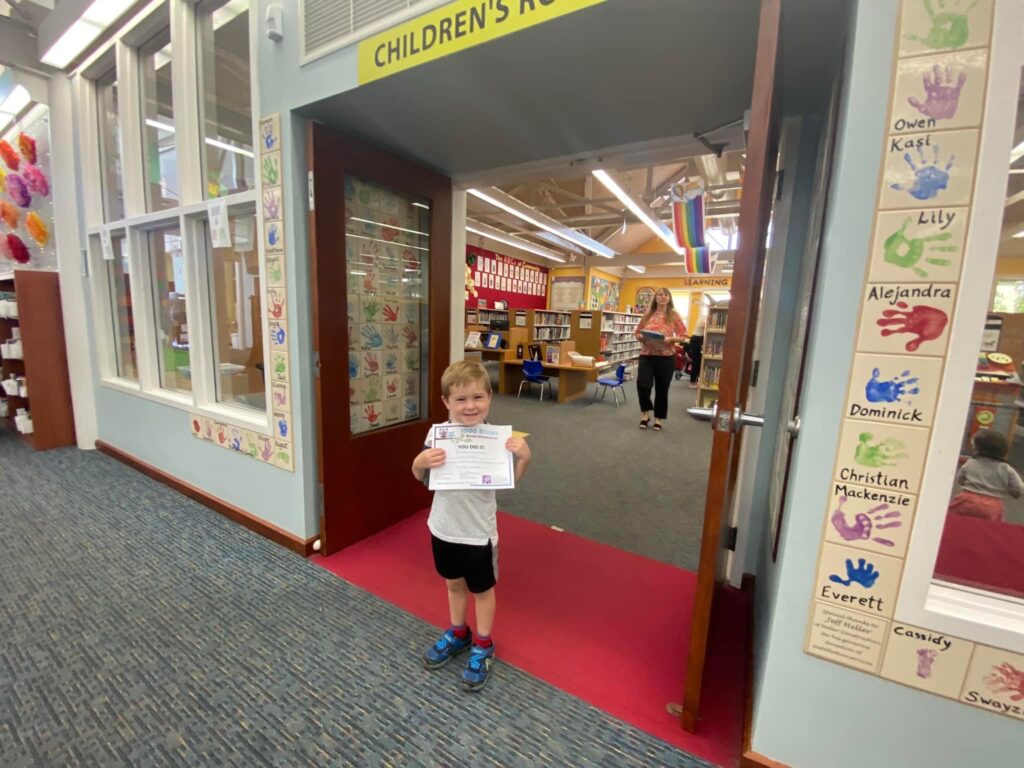 Jackson holds a certificate in a library.