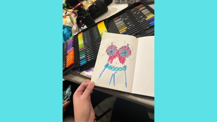 Pink, purple, and blue marker is used to create a sketch displaying the work of one youth designer. A bra top is depicted with an alternating pink and purple pattern on the outer rims of each side with blue in the middle. Blue circles depict blue condoms draped over the waist like a belt.