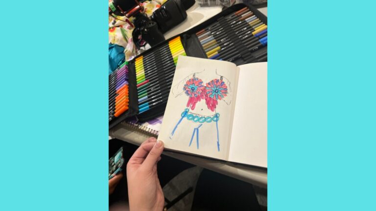 Pink, purple, and blue marker is used to create a sketch displaying the work of one youth designer. A bra top is depicted with an alternating pink and purple pattern on the outer rims of each side with blue in the middle. Blue circles depict blue condoms draped over the waist like a belt.