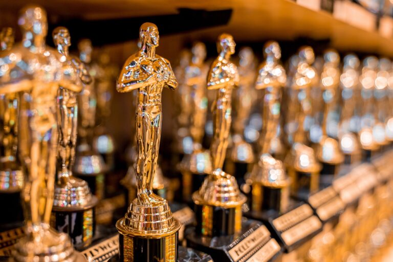 Close-up of artificial Hollywood golden oscar academy trophies arranged in a row on shelf for sale in store at Los Angeles