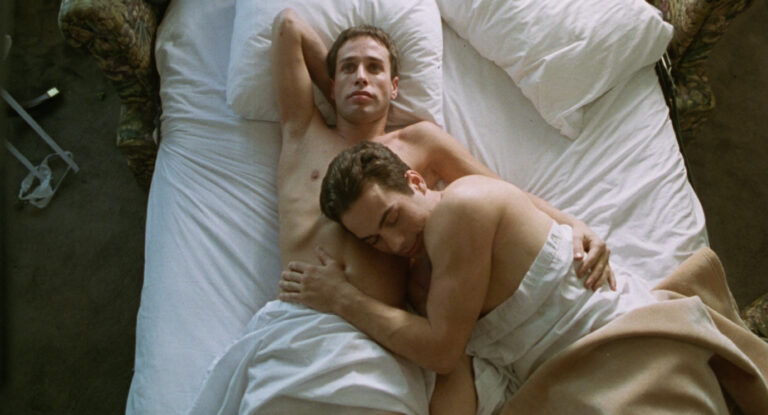 A shirtless Christian Maelen lays on top of Alexis Arquette's shirtless chest in a scene from the film 'I Think I Do'