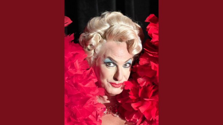 Jamison Stern in Torch Song. Jamison is wearing a blonge wig, makeup, and a red feather dress.
