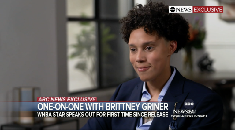 Brittney Griner smiles as she speaks with GMA's Robin Roberts. Below her is text displaying, 
