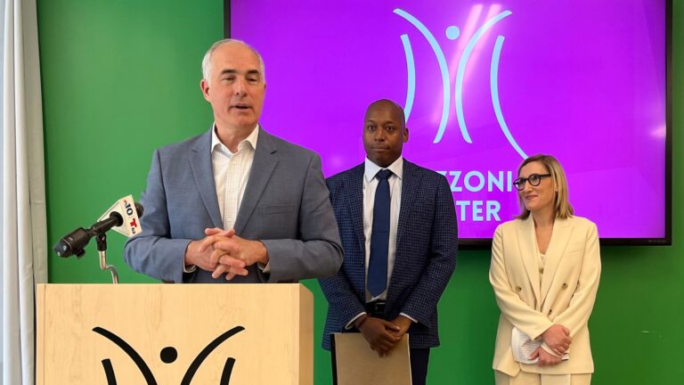 From left, Sen. Bob Casey, Mazzoni Center Executive Director and President Sultan Shakir, and Mazzoni Executive Medical Officer Dr. Stacey Trooskin. Casey speaks at a podium as Shakir and Trooskin look at him.