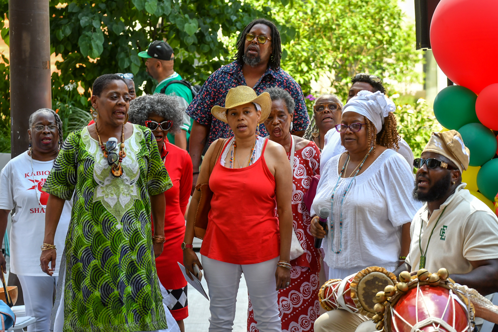 Attendees who follow Yoruba traditions participate in a drumming and singing ritual.