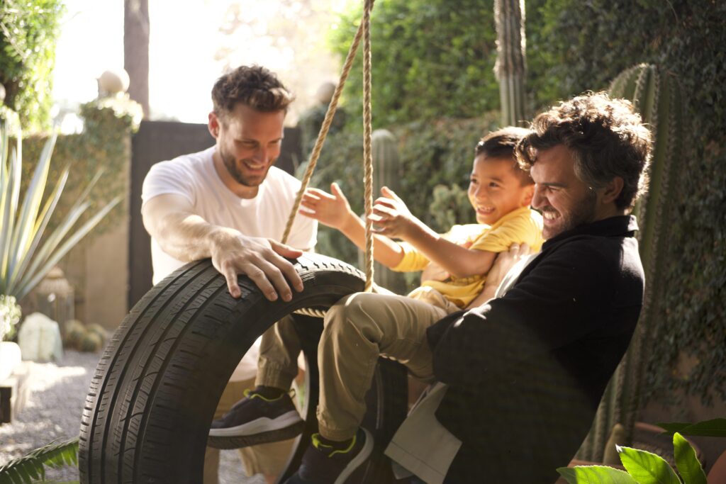 Thomas (Nico Tortorella) and Oscar (Juan Pablo Di Pace) play with Arthur (Matthew Jacob Ocampo), their first foster child. 