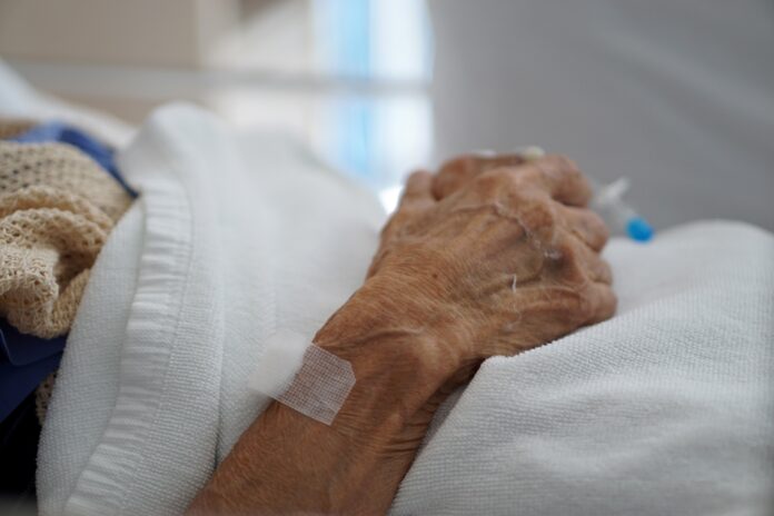 Closeup hand of sick elderly patient lying on the bed in hospital