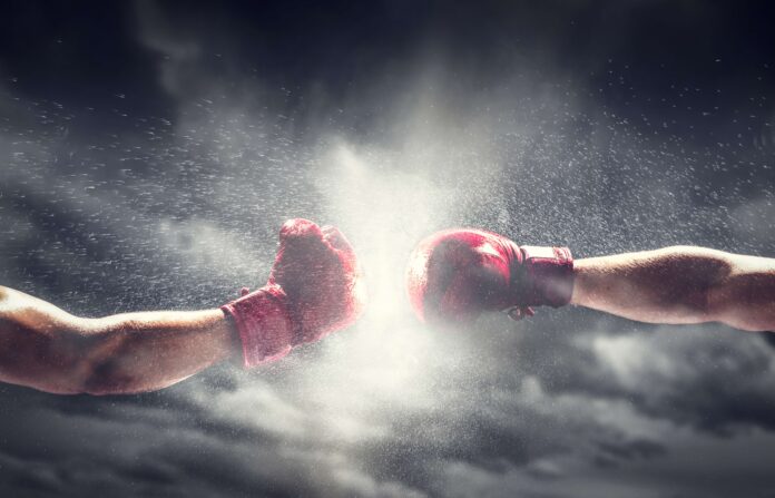 Two boxing gloves punch. Light on cloudy sky. Box, power, fight symbols.