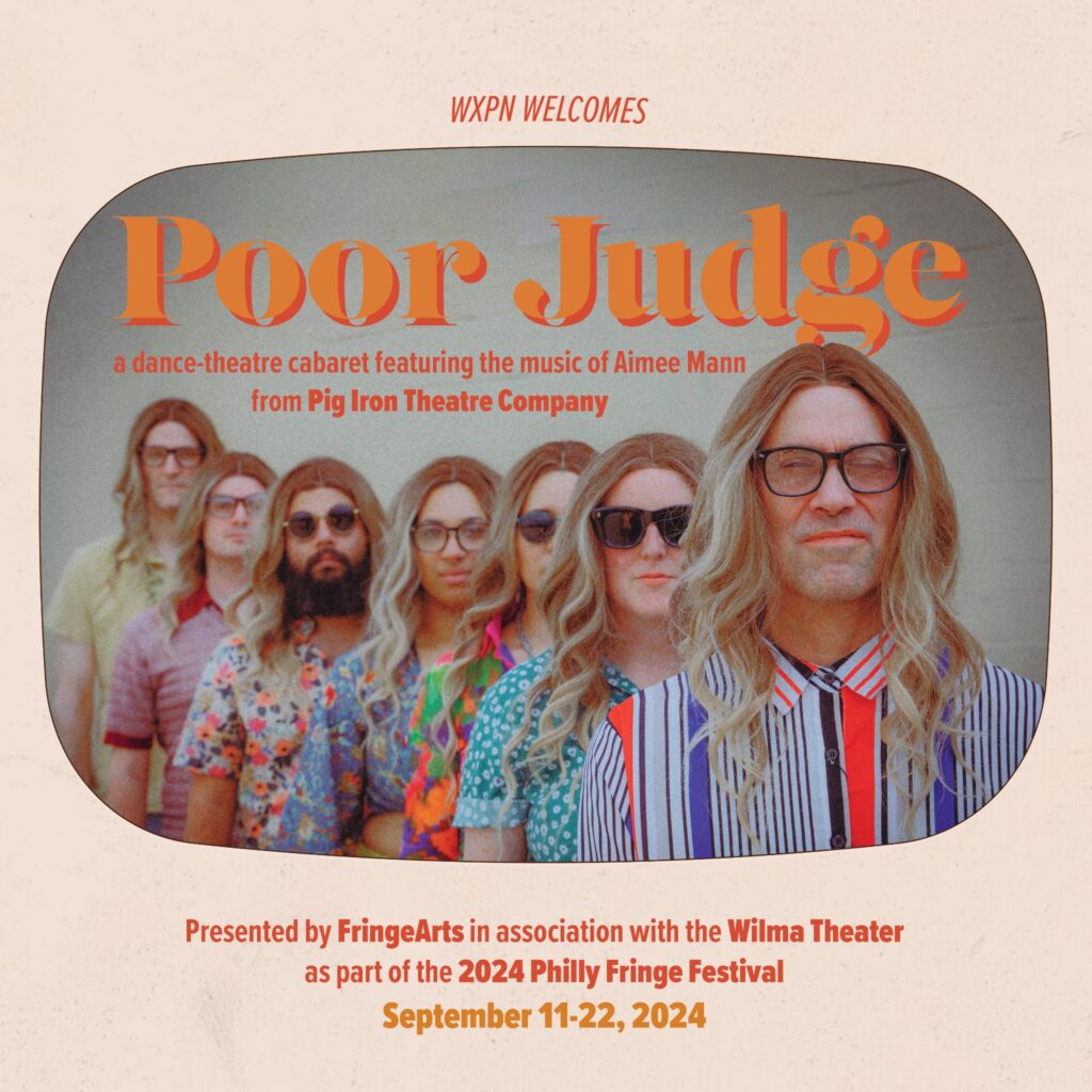 This image is a promotional poster for the dance-theatre cabaret titled "Poor Judge," presented by Pig Iron Theatre Company. The poster features a group of performers, all dressed similarly in colorful, patterned shirts and wearing long, blonde wigs and glasses. They are standing in a line, looking directly at the camera with serious expressions. The title "Poor Judge" is prominently displayed in bold orange letters, with a subtitle indicating that the show features the music of Aimee Mann. The event is part of the 2024 Philly Fringe Festival, running from September 11-22, 2024, and is presented by FringeArts in association with the Wilma Theater. The background of the poster has a retro, muted tone, giving it a vintage feel.