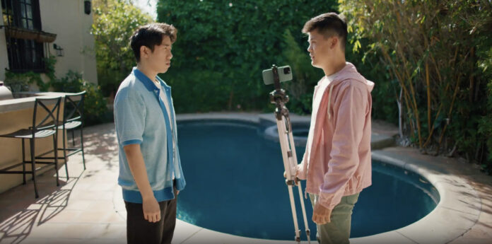 Ivan Leung and Harrison Xu look at each other while Harrison holds a camera and tripod in a scene from ‘Extremely Unique Dynamic.’