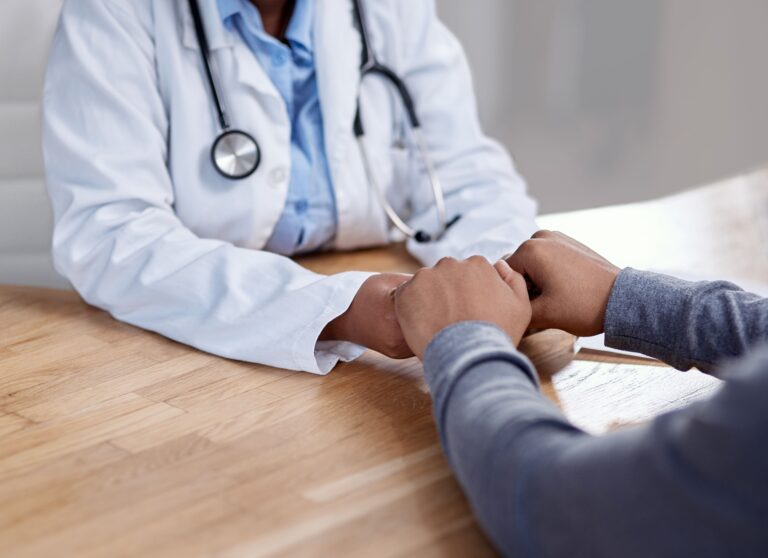 Holding hands, doctor and patient with comfort at hospital of bad news, medical diagnosis and empathy. People, surgeon and consoling for healthcare advice, compassion and treatment of wellness trust.