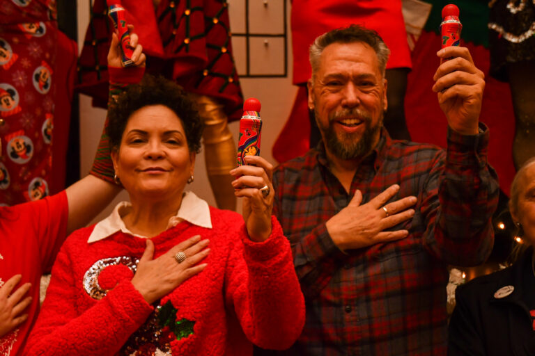 From left, Action Wellness Executive Director Mary Evelyn Torres and AIDS Fund Executive Director Robb Reichard raise bingo daubers during GayBINGO on Dec. 14 at Congregation Rodeph Shalom.