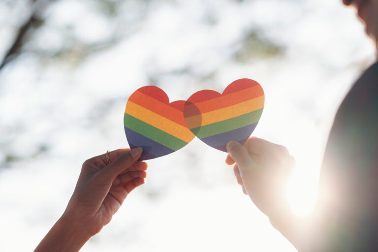 Close up hand of LGBTQ couple holding rainbow heart. LGBT rights concept. LGBTQ parents. parenting