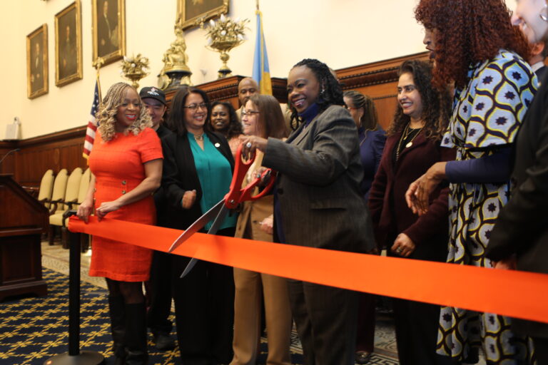 A red ribbon cutting, symbolizing the cutting of red tape for small business owners, during a press conference at Philadelphia City Hall announcing the Small Business Catalyst Fund.